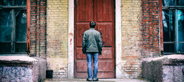 man standing in front of old door