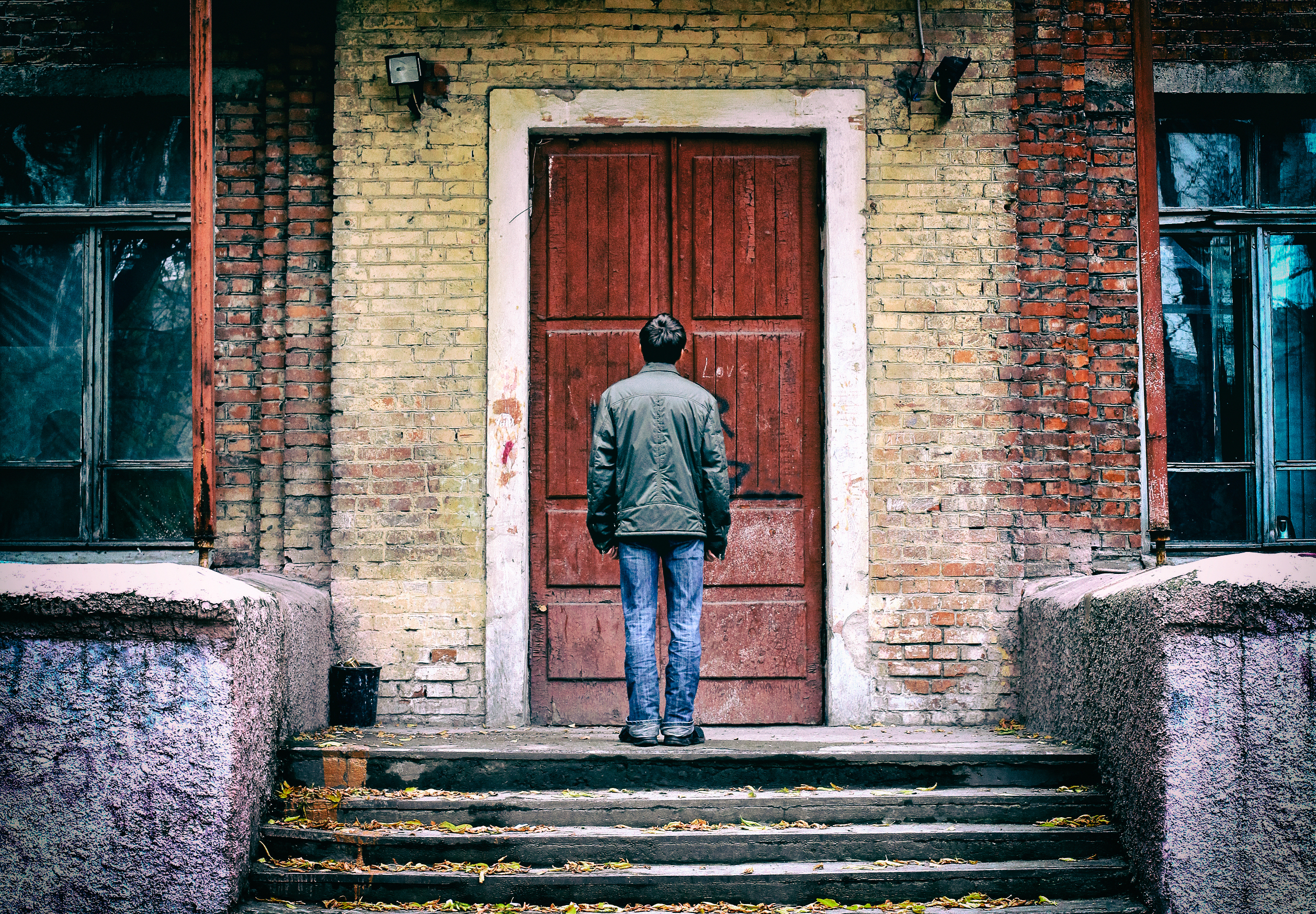 man standing in front of old door